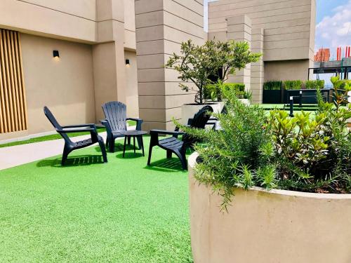 a patio with two chairs and a table and benches at GV Aparta Suites - Centro Chía in Chía