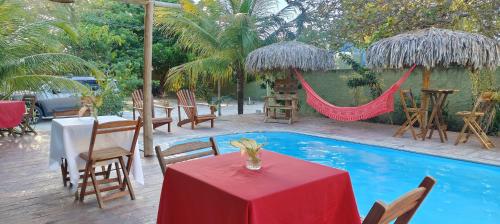 a patio with a table and a hammock next to a pool at Chalés da Cris in Fortim