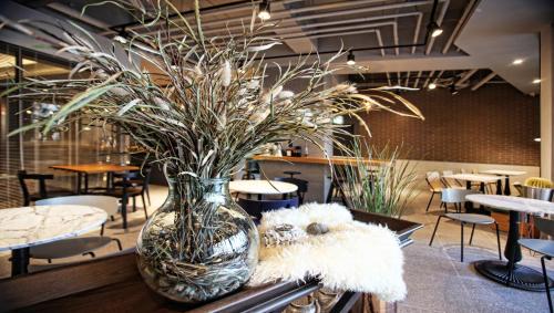 a vase with plants in it on a table at Bay Hound Hotel in Busan