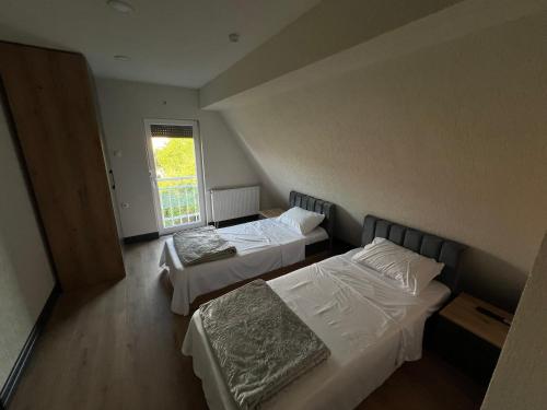 a room with two beds and a window at Panorama Residence Apartments in Kumanovo