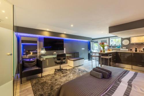 a bedroom with a bed and a desk and a kitchen at The Orange Canals Suite in Amsterdam