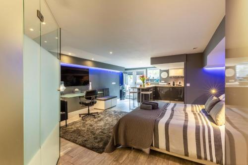 a bedroom with a bed and a desk and a kitchen at The Orange Canals Suite in Amsterdam