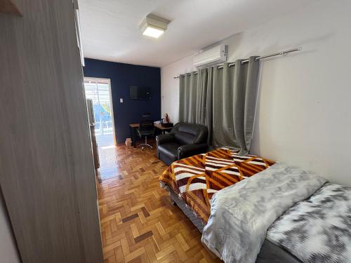 a bedroom with a bed and a chair in it at Suite Privativa in Dom Pedrito
