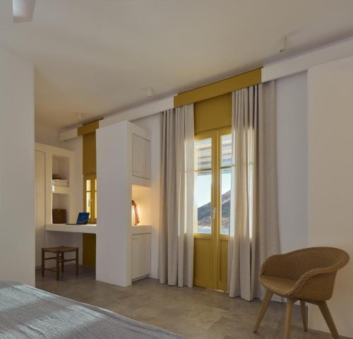 a bedroom with a bed and a desk and a window at Amorgina in Amorgos