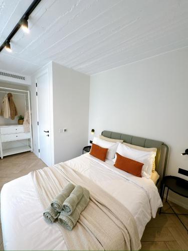 a white bedroom with a large bed with towels on it at Stylish Designer Apartment in Mellieħa