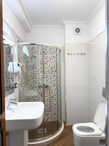 a bathroom with a shower and a toilet and a sink at Bamisa Apartments in Golem