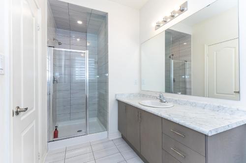 a white bathroom with a shower and a sink at Home in Waterdown in Hamilton