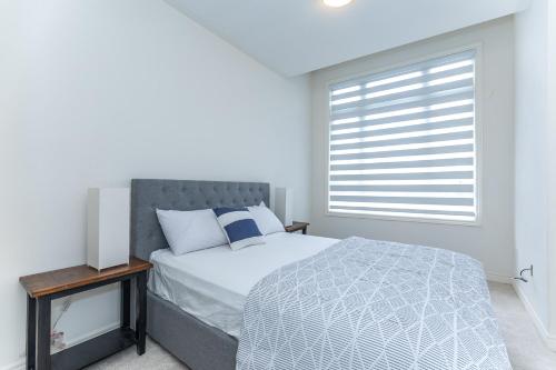 a white bedroom with a bed and a window at Home in Waterdown in Hamilton