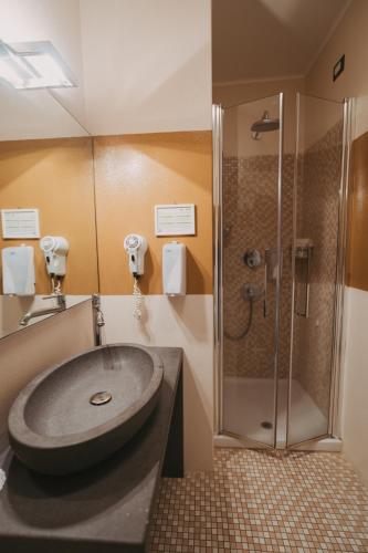 a bathroom with a sink and a shower at Antica Dimora Del Gruccione, Albergo diffuso in Santu Lussurgiu