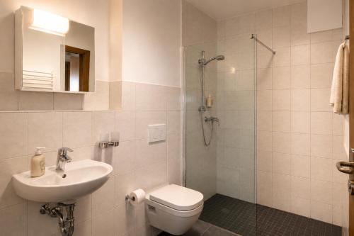 a bathroom with a toilet and a sink and a shower at i-Motel Obertshausen nahe Frankfurt in Obertshausen