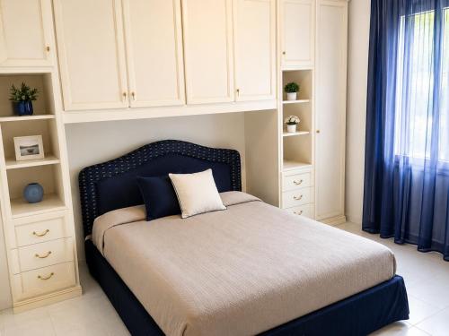 ein Schlafzimmer mit einem Bett mit blauem Kopfteil in der Unterkunft Residence Garbin - Agenzia Cocal in Caorle