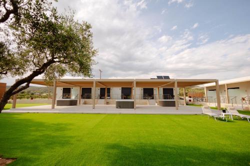 a building with a green lawn in front of it at Aura Otto Luxury Living in Alexandroupoli