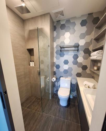 a bathroom with a toilet and a shower and a sink at Ceylonz Suites By ANA MALAYSIA in Kuala Lumpur