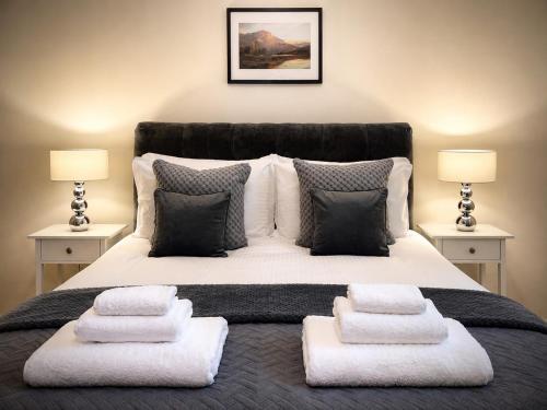 a bedroom with a large bed with white blankets and pillows at Lomond Castle Penthouse in Luss