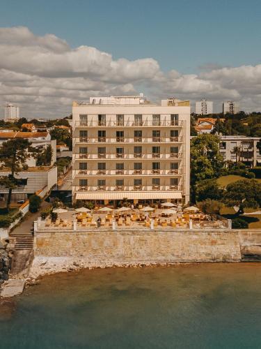 a large white building next to a body of water at Hôtel Les Brises in La Rochelle