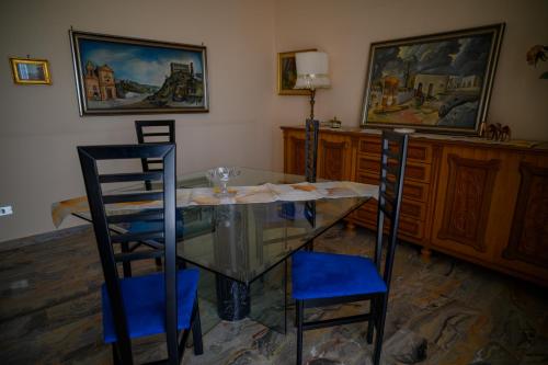 a dining room with a glass table and two chairs at Tiz Home il Tuo Rifugio di Charme nel Cuore della Sicilia autentica in Canicattì