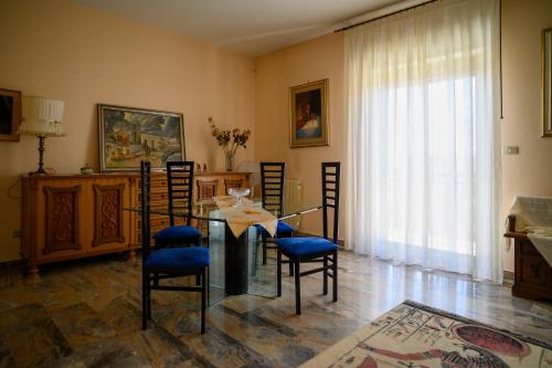 a dining room with a glass table and chairs at Tiz Home il Tuo Rifugio di Charme nel Cuore della Sicilia autentica in Canicattì