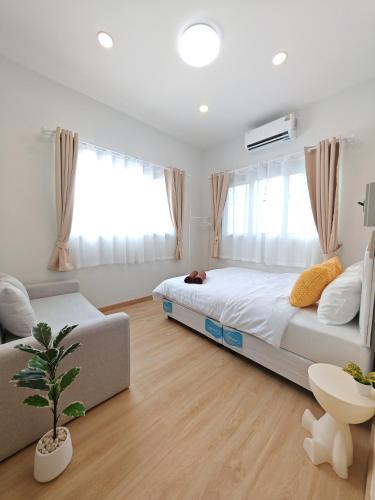 a bedroom with a bed and a couch at The paperwhite poolvilla khaoyai in Ban Tha Chang