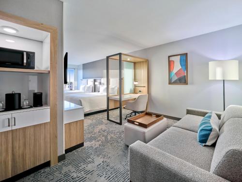 a living room with a couch and a bedroom at SpringHill Suites by Marriott Phoenix Gilbert in Gilbert