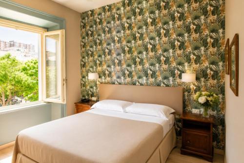 a bedroom with a bed and a floral wallpaper at Hotel della Vittoria in Ancona