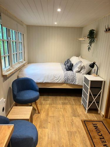 a bedroom with a bed and a chair in it at Half Moon Shepherds Huts in Plumpton