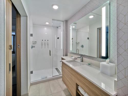 a bathroom with a large mirror and a sink at SpringHill Suites by Marriott Phoenix Gilbert in Gilbert