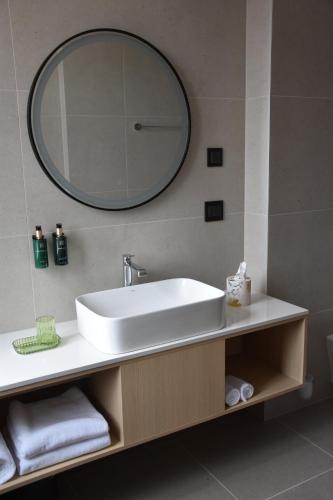 a bathroom with a white sink and a mirror at Hotel Dom in Studenci