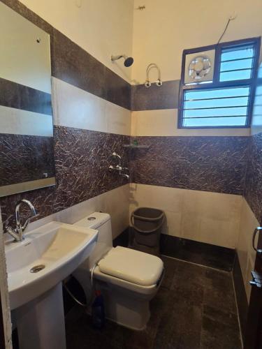 a bathroom with a toilet and a sink at The Cozy Theory in Kharar