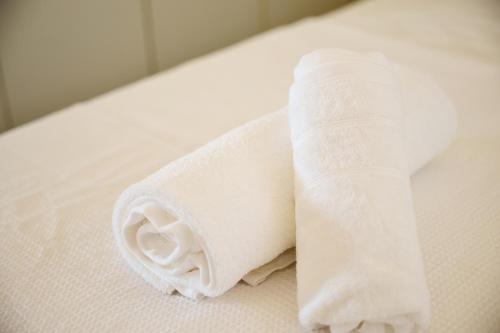 a roll of white toilet paper sitting on a bed at pRETTy Home with Private Pool, Sea View in Nea Kallikrateia