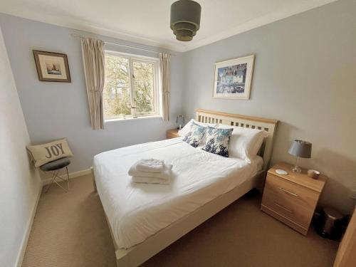 a bedroom with a white bed with a window at Yarg Cottage in Falmouth