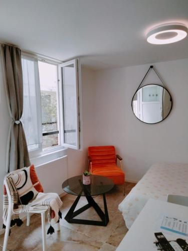 a living room with a table and a chair at Duplex Hyper centre-ville 10 in Quimper