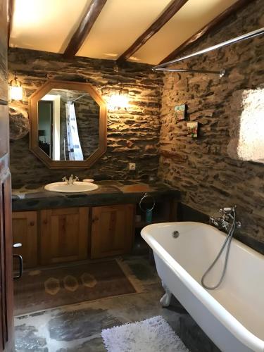 a bathroom with a bath tub and a sink at Herdade Do Vale Coelheiro in Toulões