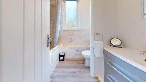 a bathroom with a sink and a toilet and a window at 39 Strawberry Hill, Tolroy Manor in Hayle