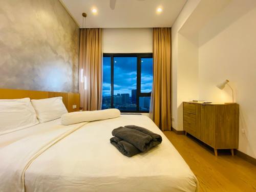 a bedroom with a large white bed with a window at Luxury Suites By Lucentia Residence BBCC Kuala Lumpur in Kuala Lumpur