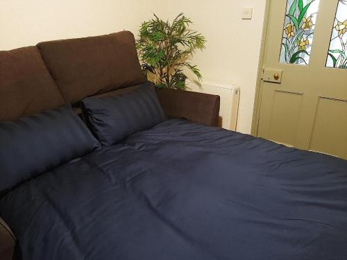 a large bed with blue sheets in a bedroom at Quirky hideout in town centre in Wimborne Minster