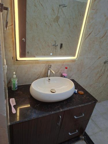 a bathroom with a sink and a large mirror at Prem niwas in Kakarmatha