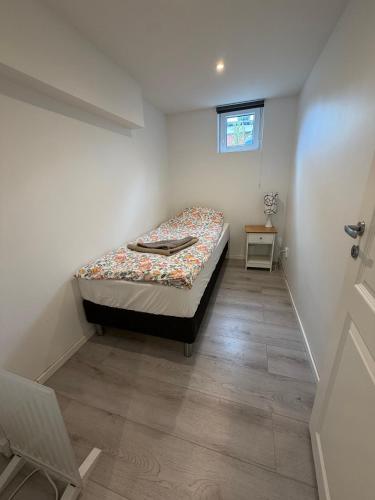 a small bedroom with a bed and a window at Spacy flat with big garden in Södertälje