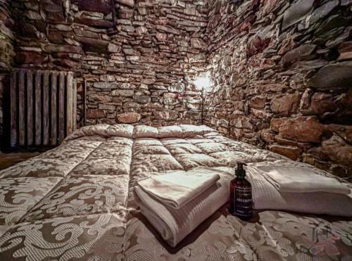a bedroom with a bed in a stone wall at Soqquadro Art&Relax Alassio - Romantico Frantoio 1600 in Alassio