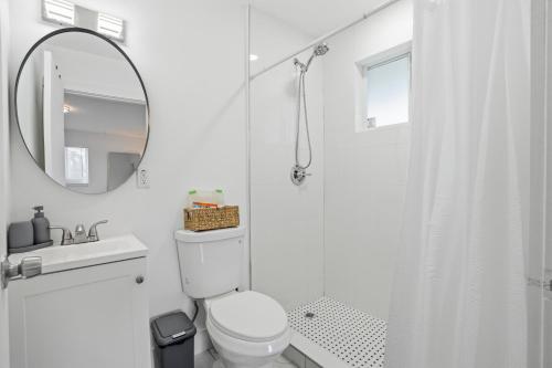 a white bathroom with a toilet and a mirror at 11430 Lincoln Blvd in Richmond Heights