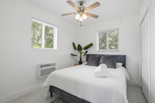 a bedroom with a white bed with a ceiling fan at 11430 Lincoln Blvd in Richmond Heights