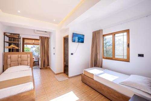a bedroom with two beds and a living room at Hotel ENAD in Ksamil