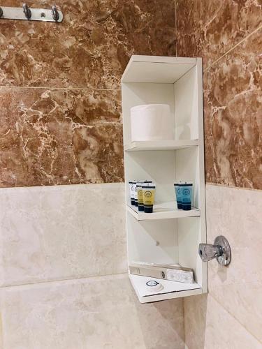 a white shelf in a bathroom next to a shower at منازل الضيف in Jeddah