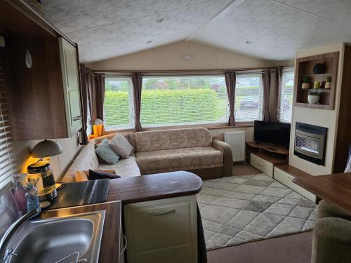 a living room with a couch and a tv in a caravan at High View in Freystrop