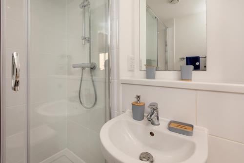 a white bathroom with a sink and a shower at Stylish City Centre Studio, Sleeps 2 in Sheffield
