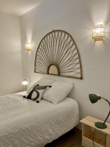 a bedroom with a bed with a large headboard at Balcon sur les vignes - Loft de charme 2 pers in Cournanel