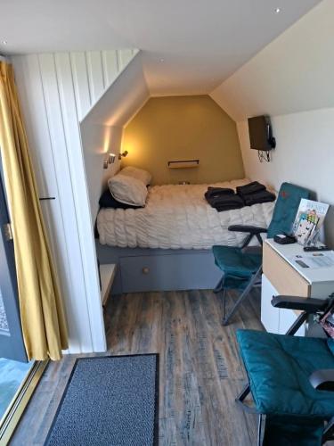 a small room with a bed and a desk and chair at The Orkney Pod in Stromness