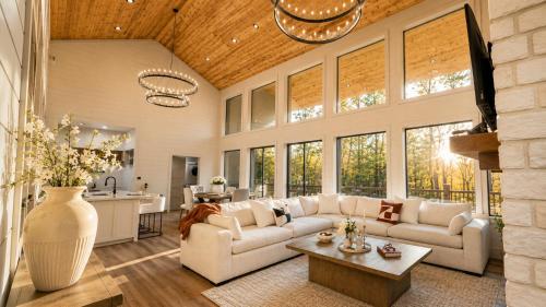 a living room with a couch and a table at Creek,Pool,Playhouse celebration estate, sleeps 21 in Broken Bow