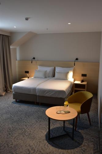 a hotel room with a bed and a table at Hotel Dom in Studenci