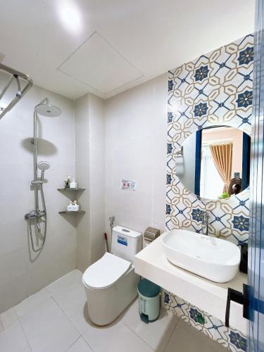 a bathroom with a toilet and a sink and a mirror at Santo house in Thôn Trường Giang