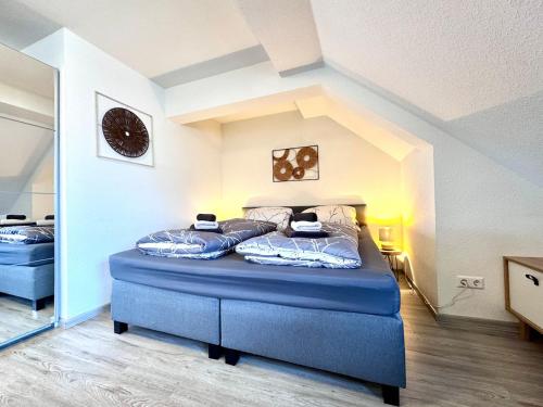 a bedroom with a blue bed in an attic at Ferienwohnung Artemis in Eggingen